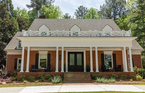 This traditional front porch with a brick facade makes for an inviting entry.