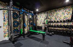 Custom home gym with exciting colorful wallpaper.